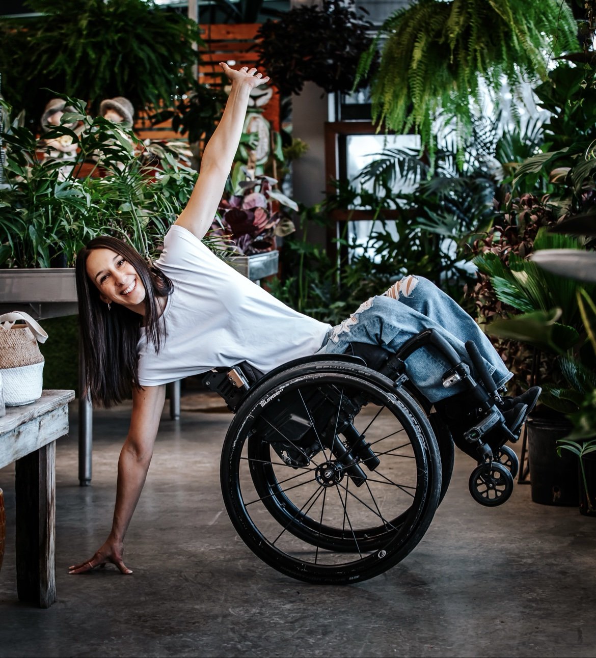 Ollie souriante en fauteuil roulant parmi les plantes